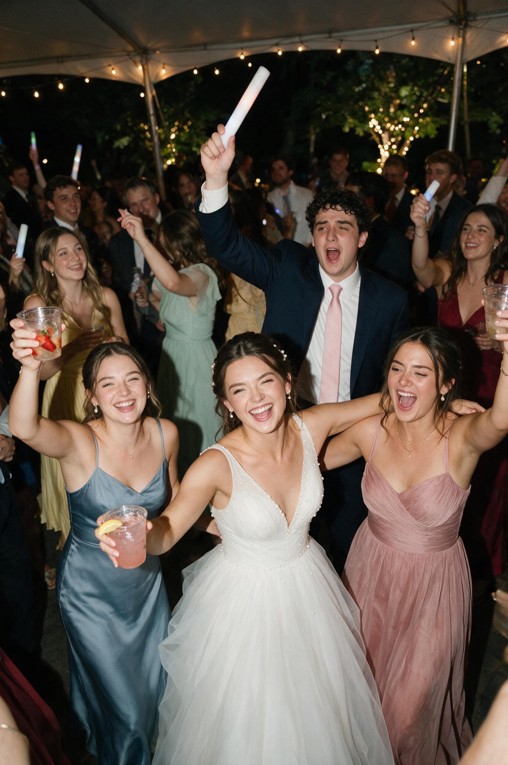 Bride celebrating on the dance floor with bridesmaids